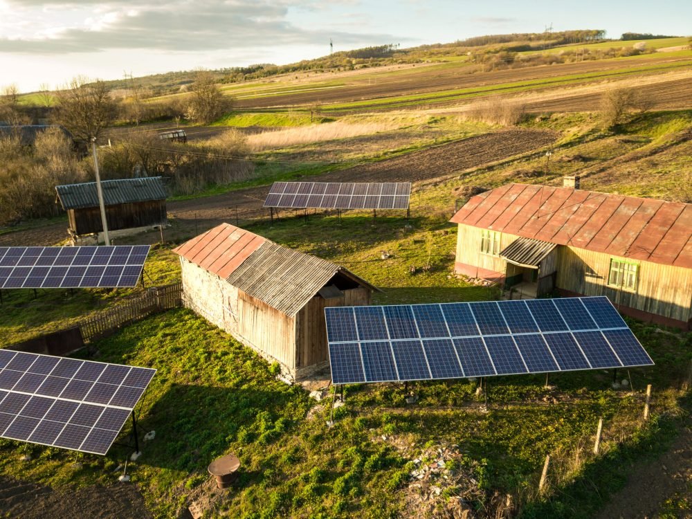 Aerial top down view of solar panels in green rural village yard.